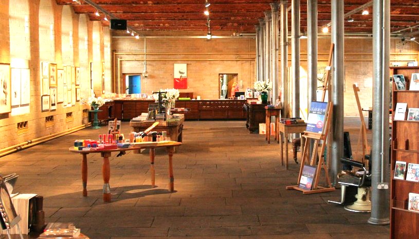 Saltaire, Salts Mill, Interieur mit runden Gusseisensäulen und äußerer Ziegelwand (c) Wiki Media